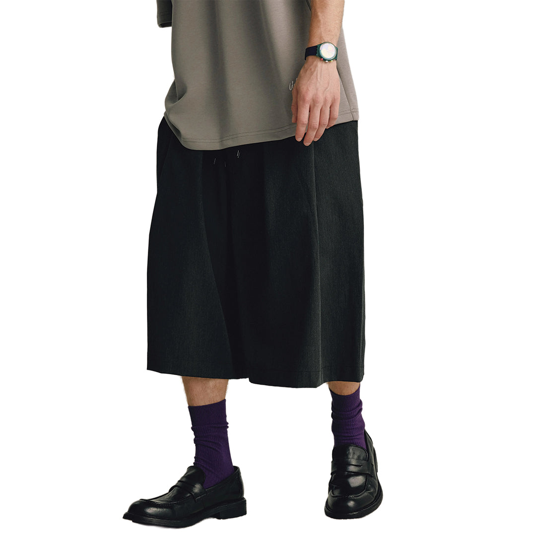 Men's wide-leg calf-length trousers in monochrome with fluid draped pleats and elastic drawstring waist