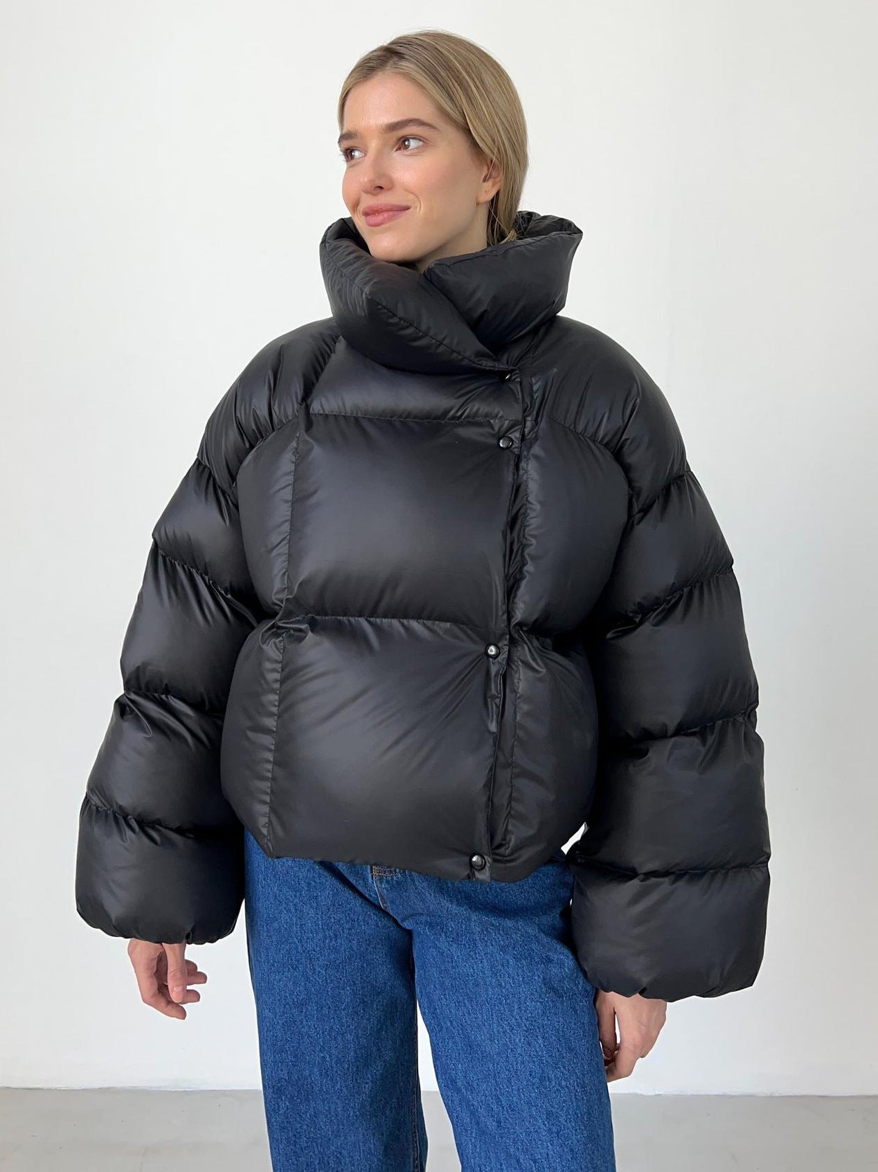 Black quilted puffer jacket with oversized hood, relaxed fit, insulated for cold weather city wear