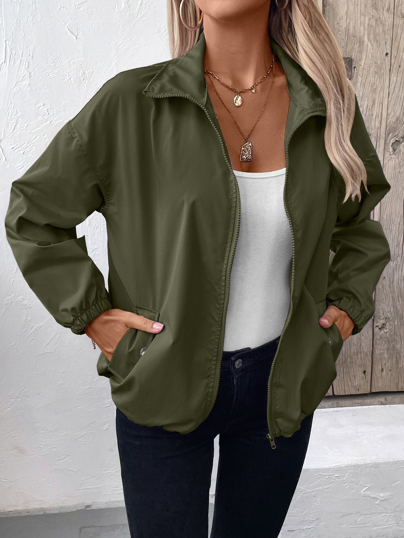 Women's lightweight waterproof raincoat in neutral tone, slim outdoor fit with moisture-barrier protection