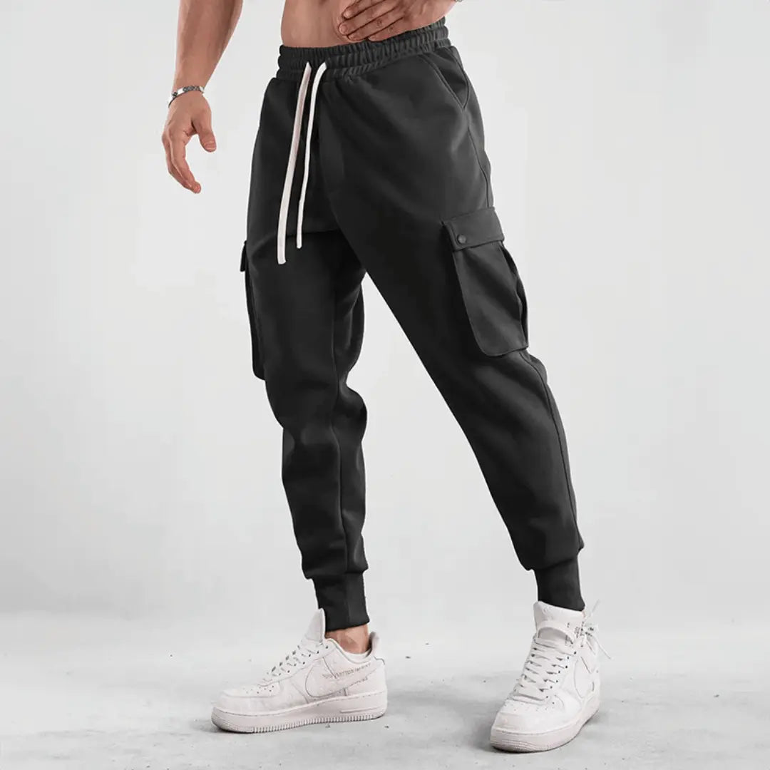 Black cargo joggers with adaptive flex fabric, tapered street-fit cut, and multi-pocket utility design