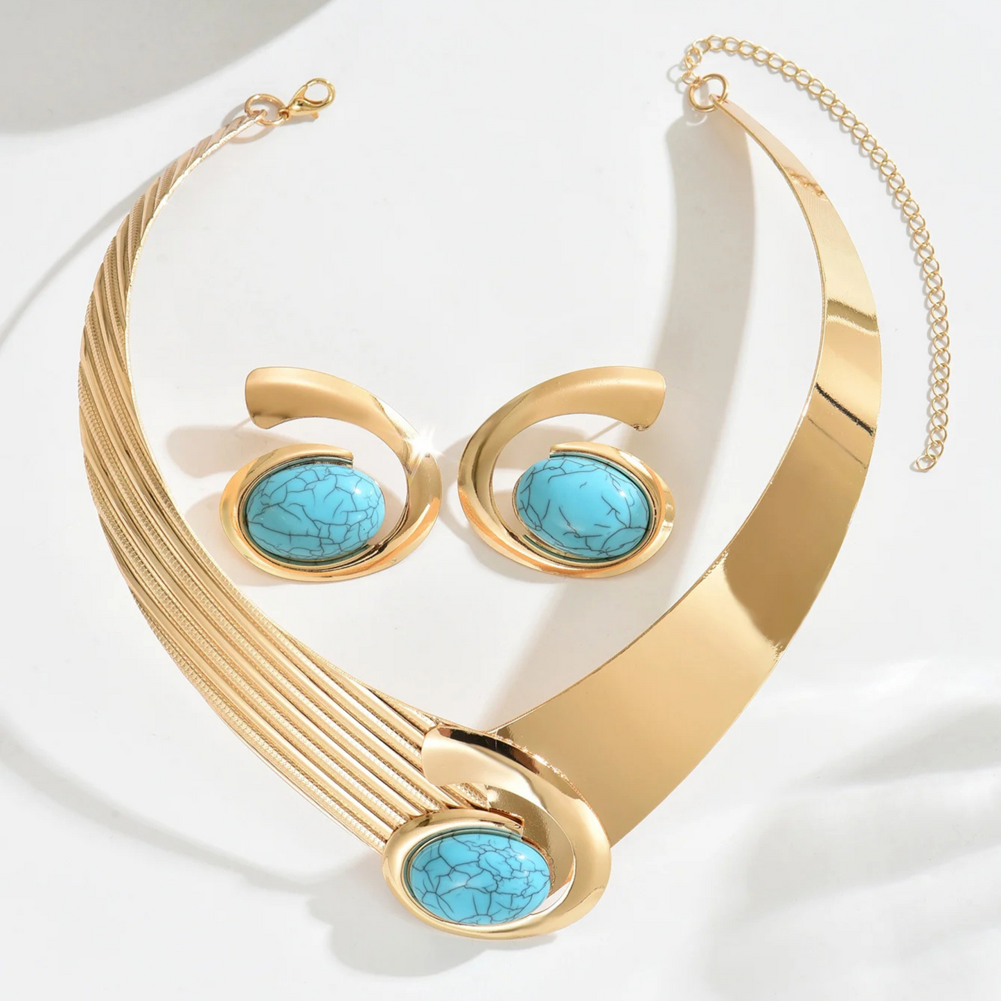 Asymmetrical gold-tone statement necklace and earring set with mirror-finish opal resin centerpiece