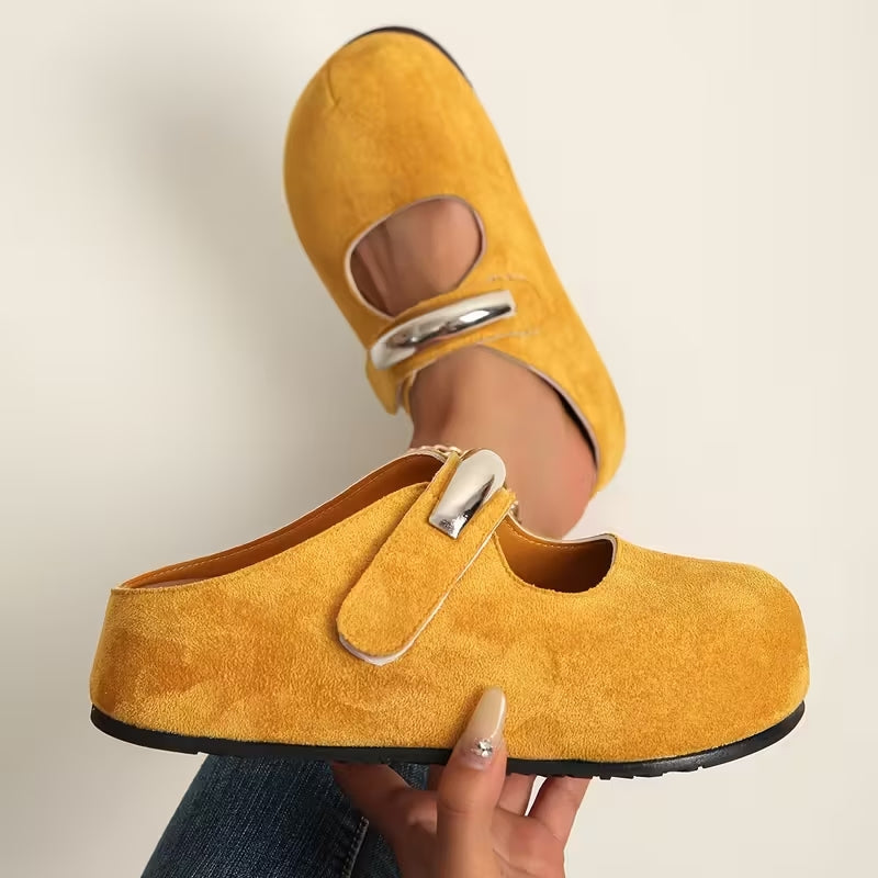 Women's suede slip-on shoes with sculpted sole and bold metallic clasp accent for everyday wear