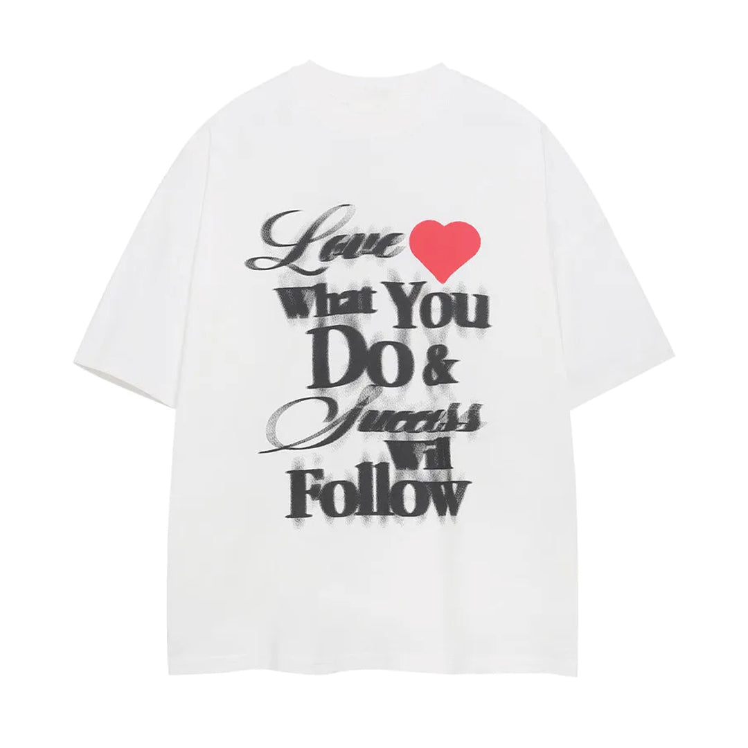 White cotton relaxed-fit tee with bold spray-print "Love What You Do" text and bright heart motif