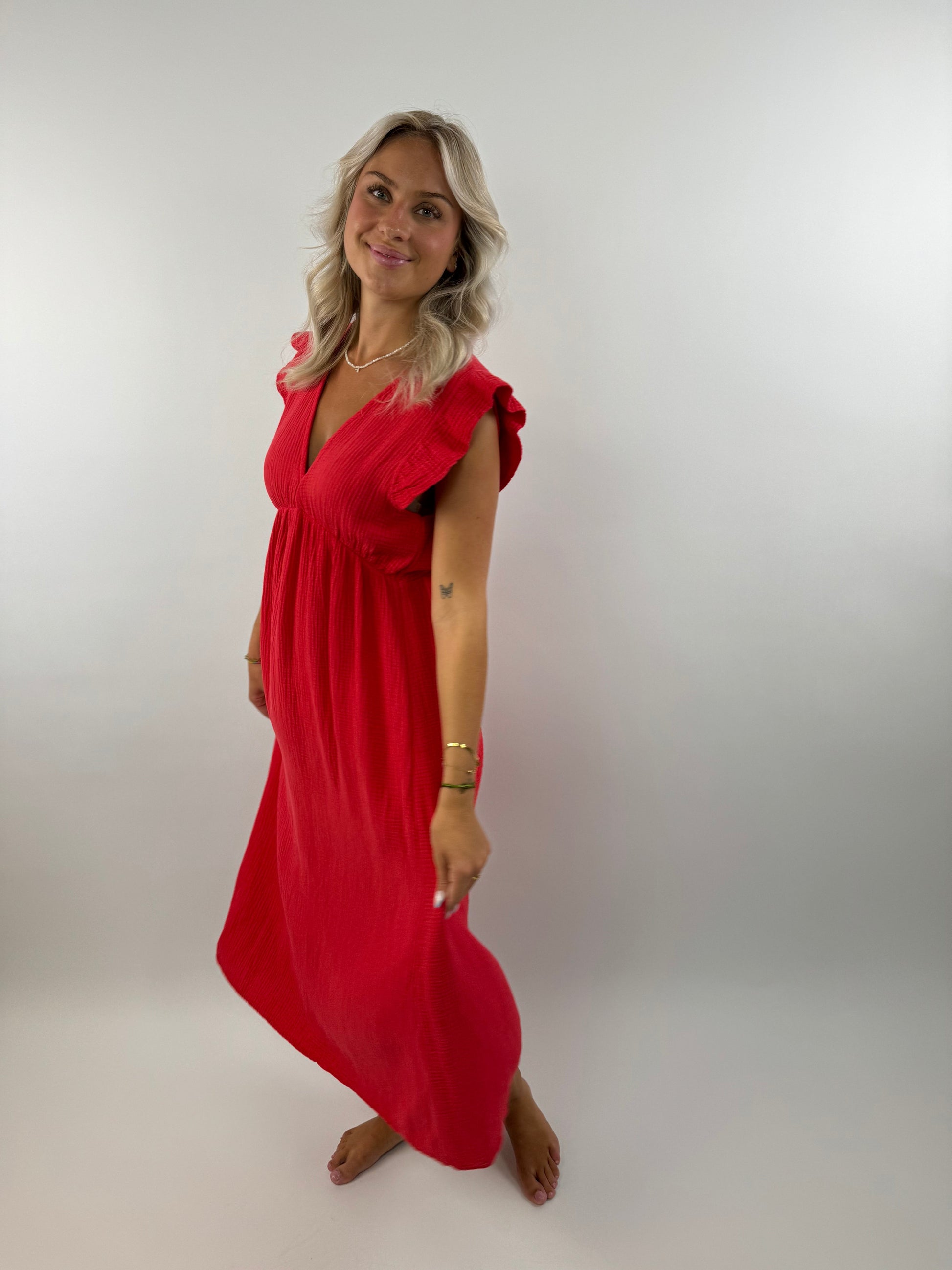Ivory muslin midi dress with flowing silhouette, delicate ruffles, and lightweight airy fabric for special occasions