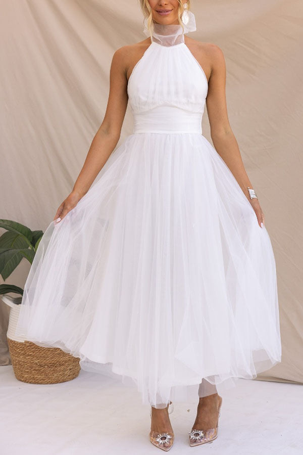 Black midi halter neck dress with open back, elegant fluid silhouette for formal occasions