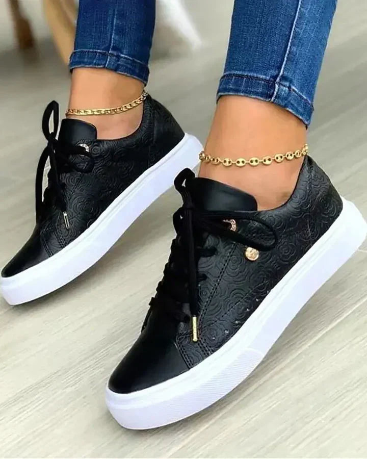 Gold-accented fashion sneakers in neutral tones, sleek low-top silhouette with metallic detail