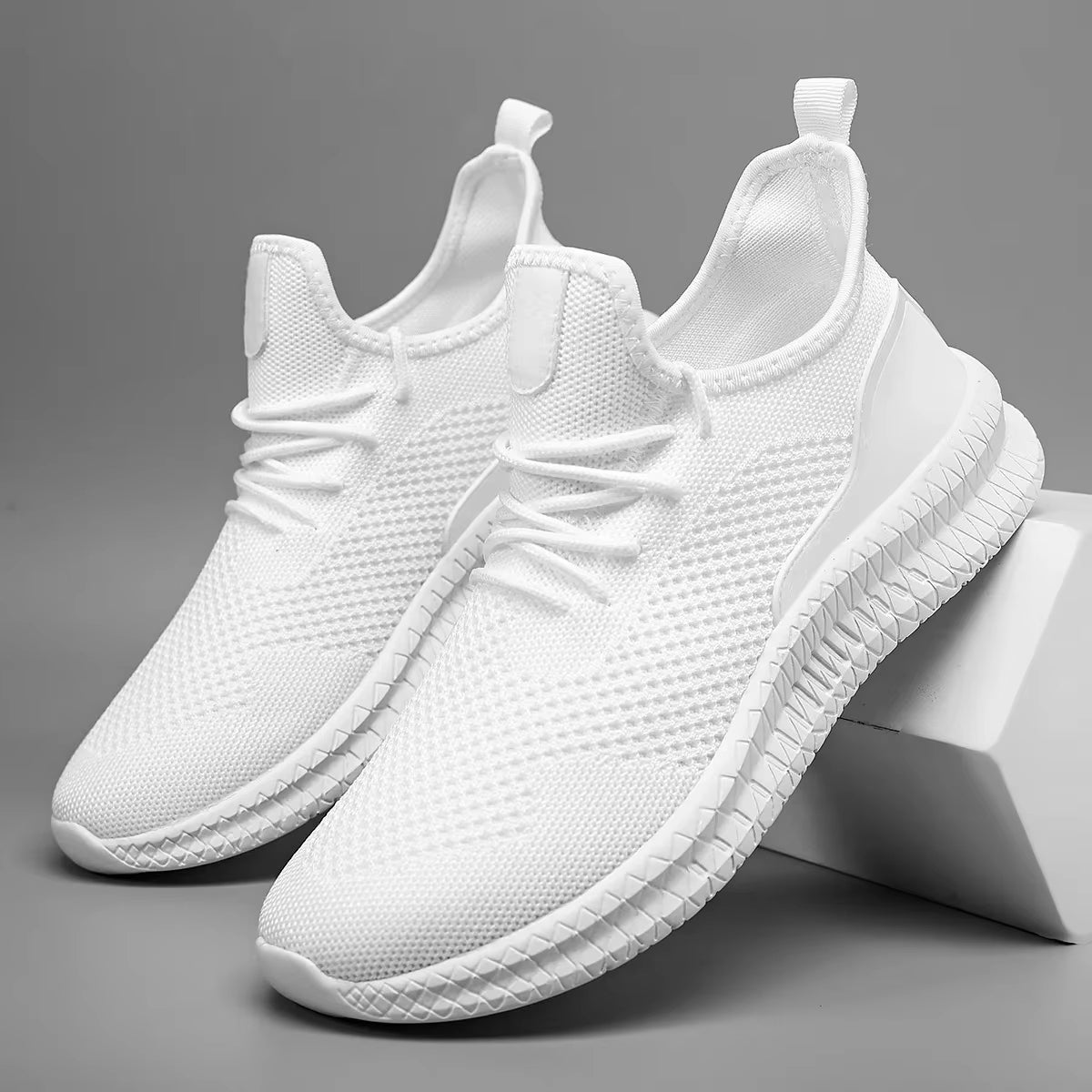 White lightweight athletic mesh sneaker with adaptive knit upper, airflow design, and all-day grip sole