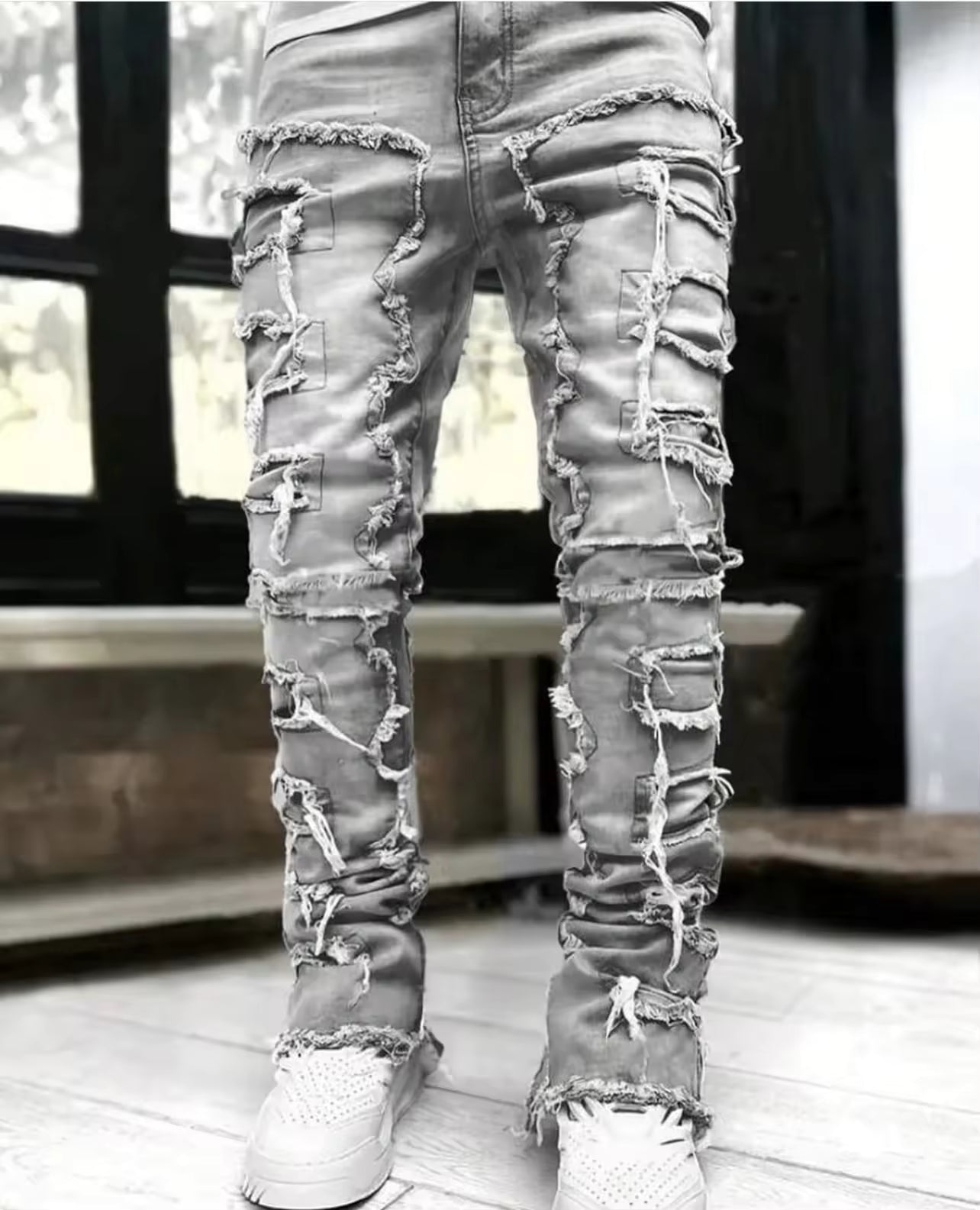 Distressed layered stretch denim tapered jeans with heavy fraying and reinforced seams streetwear style