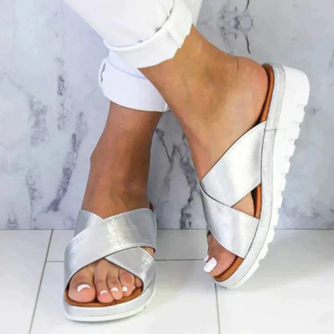 Women's beige crisscross slip-on sandals with textured faux leather upper and cushioned platform sole