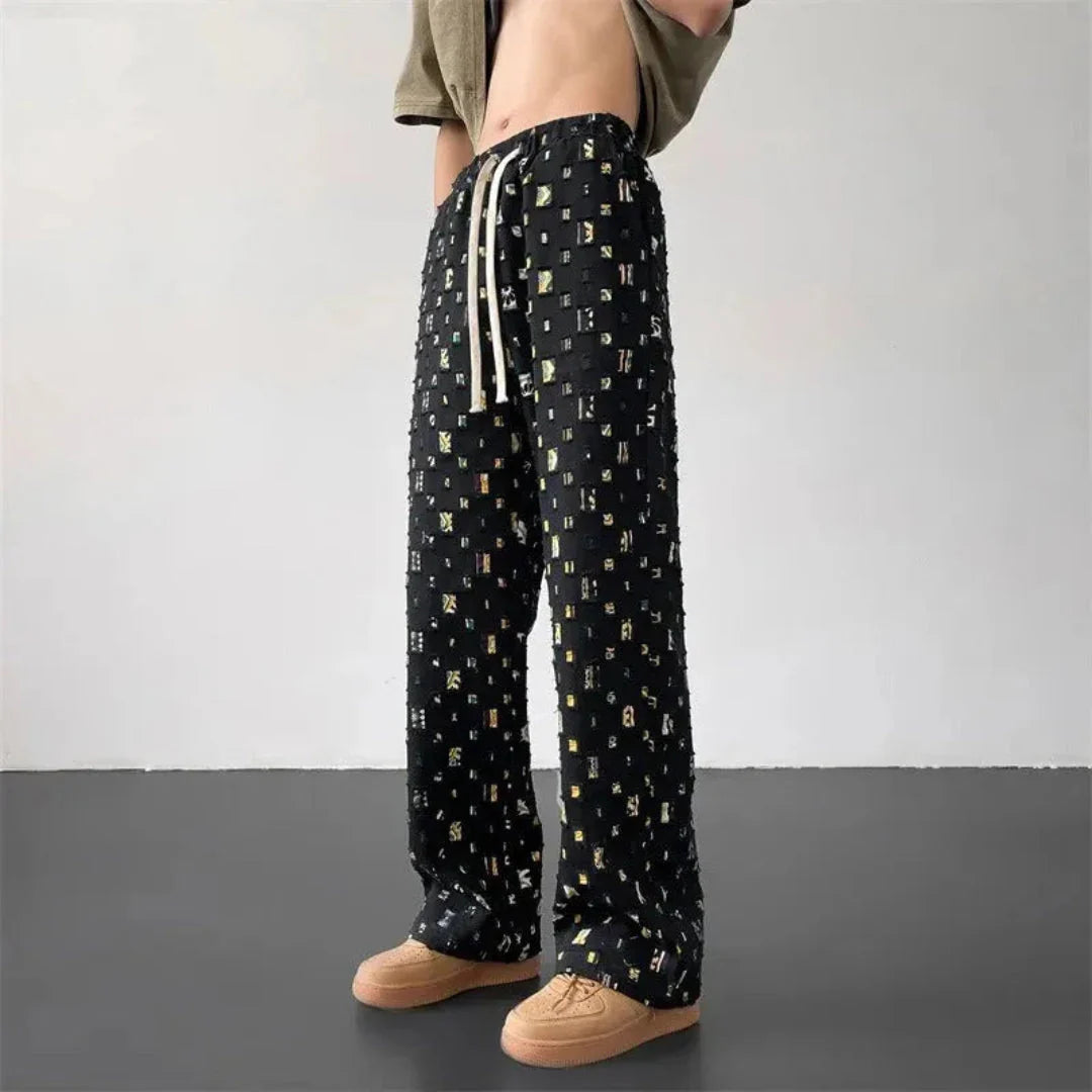 Black cotton canvas streetwear pants with bold 3D geometric patchwork grid cut-out design