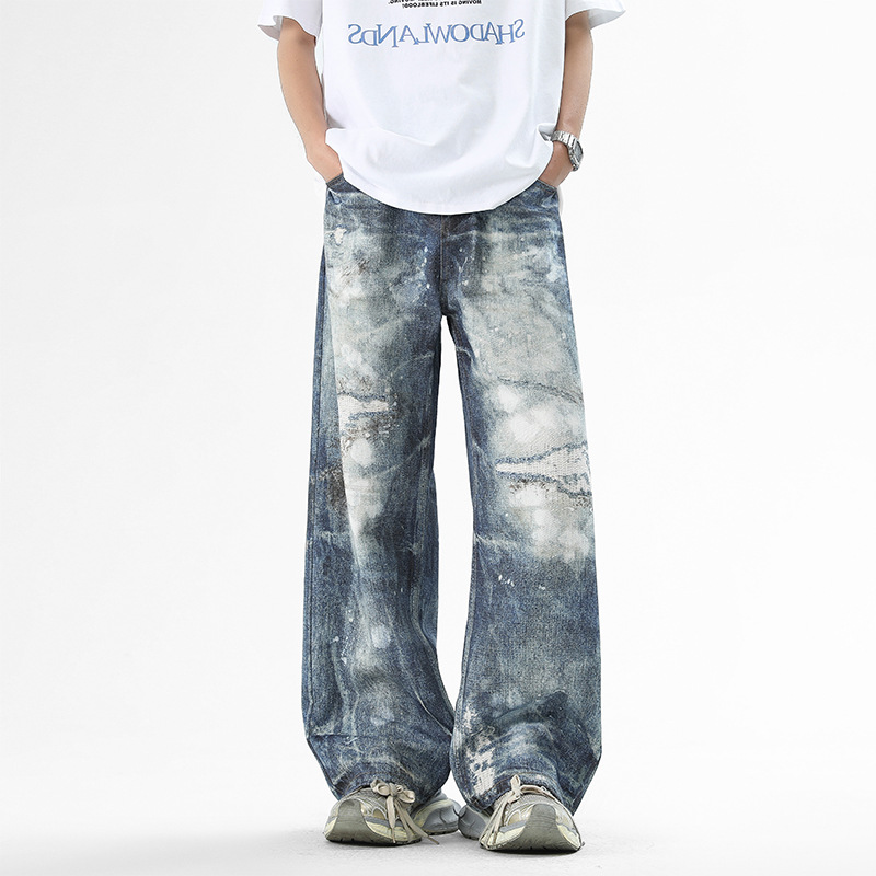 Blue denim wide-leg jeans with vivid all-over paint splatter print for urban creative style