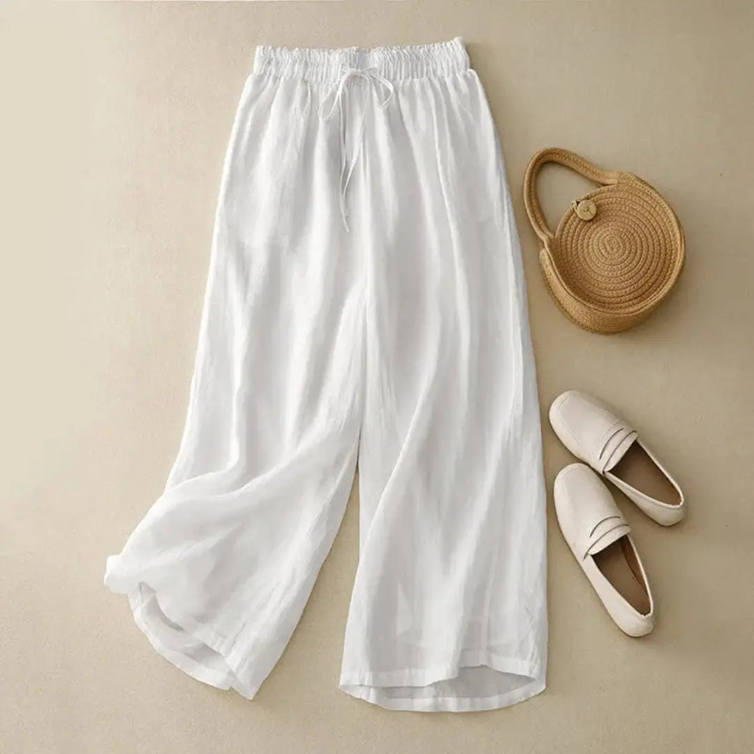 Women's white linen high-waist wide-leg pants with drawstring waistband, flowy elegant silhouette
