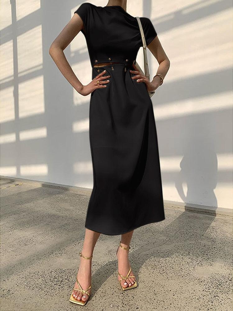 Black cap sleeve midi dress with elegant cutout detail, polished office-ready silhouette with metal accents