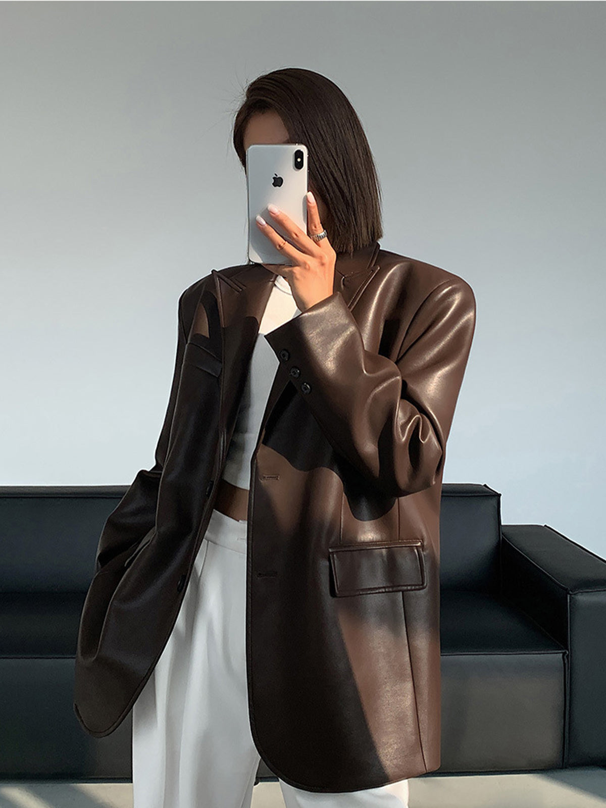 Women's oversized faux leather blazer with lapel collar, bold structured silhouette in sleek finish