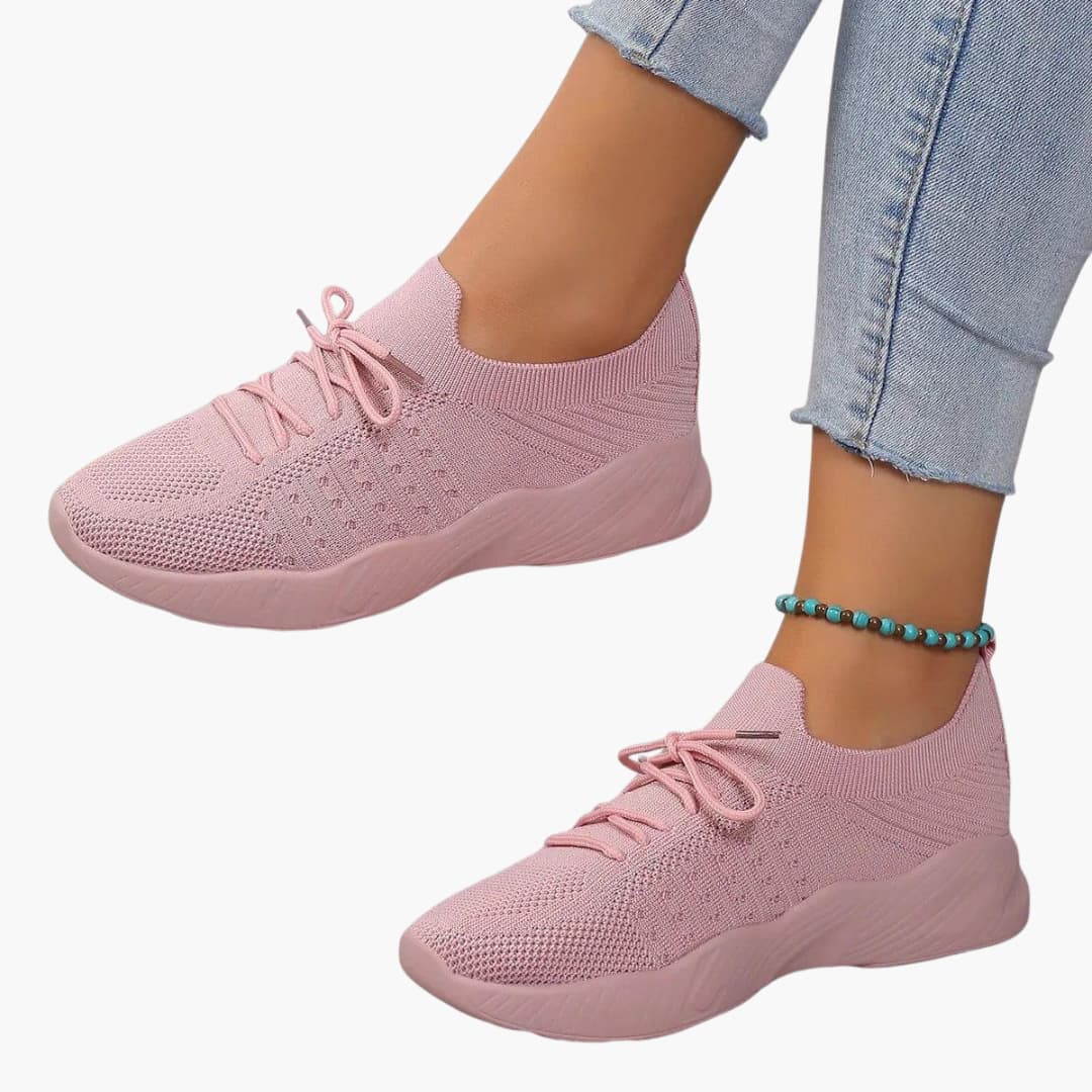 Women's white lace-up sneakers with breathable mesh upper, low-cut silhouette, and flexible sole