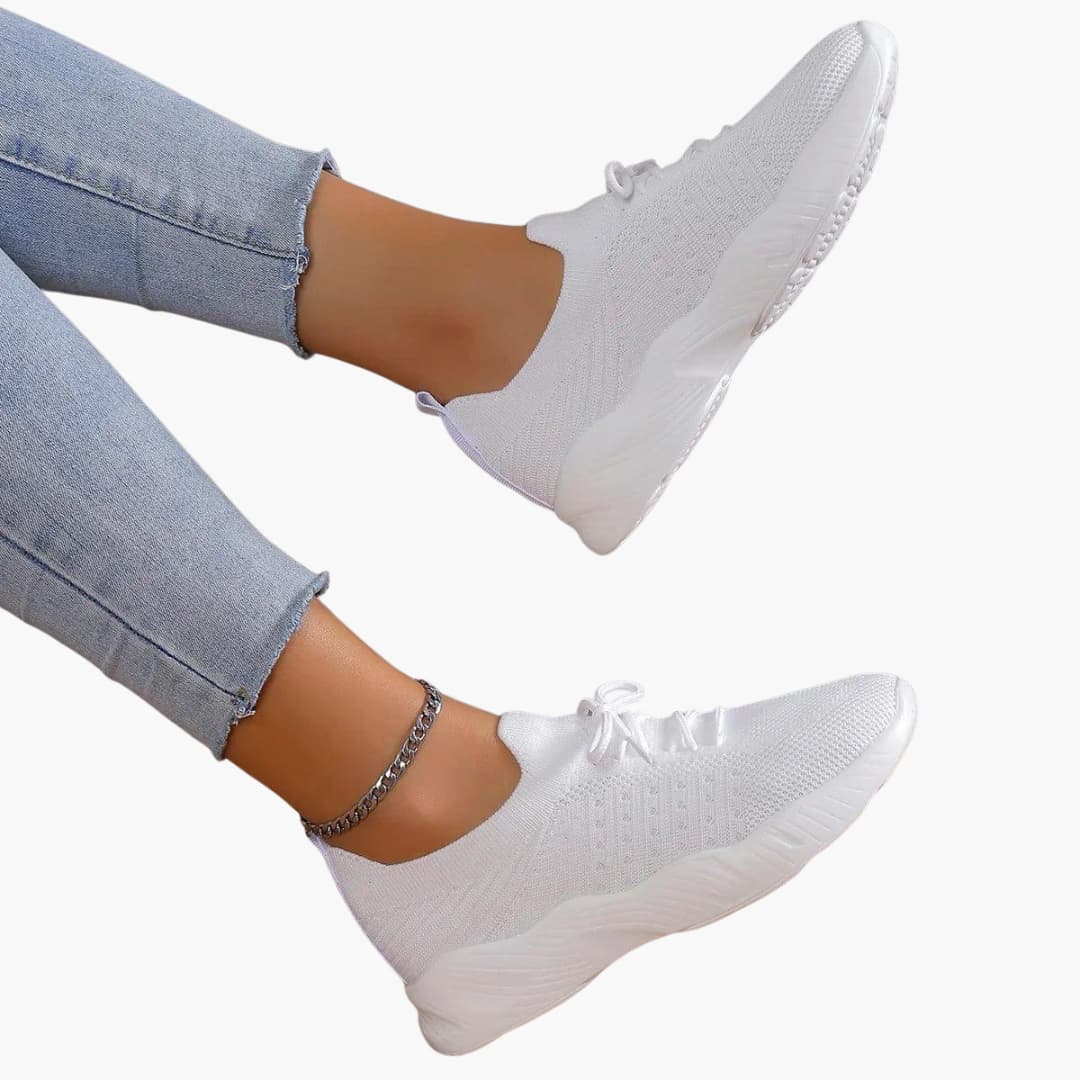 Women's white lace-up sneakers with breathable mesh upper, low-cut silhouette, and flexible sole