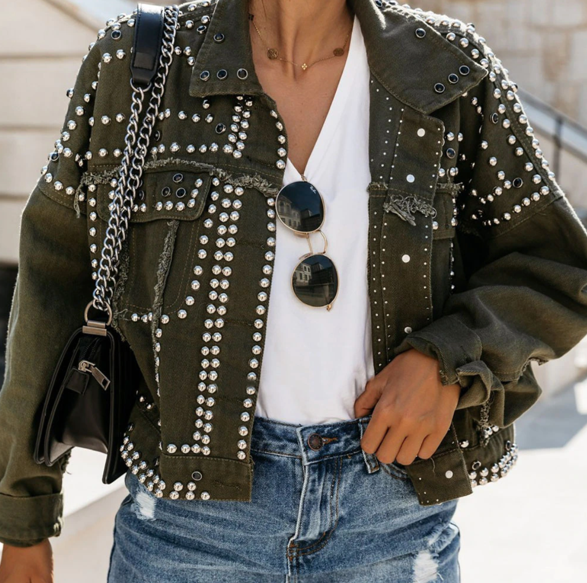 Women's black cropped studded jacket with allover silver studs and raw-edge seams for edgy style