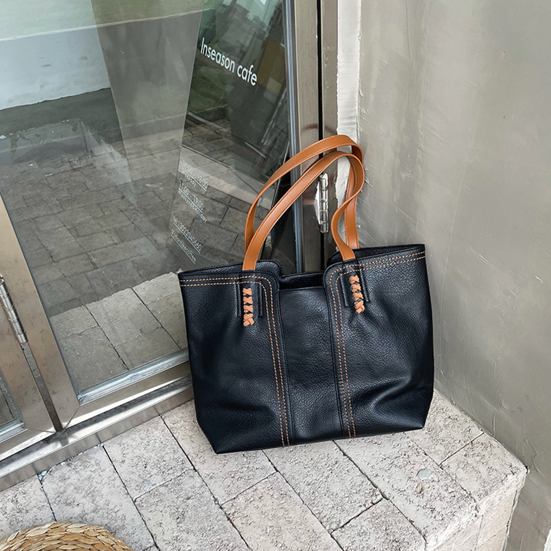 Black PU leather women's tote bag with elegant inner compartments and zipper closure