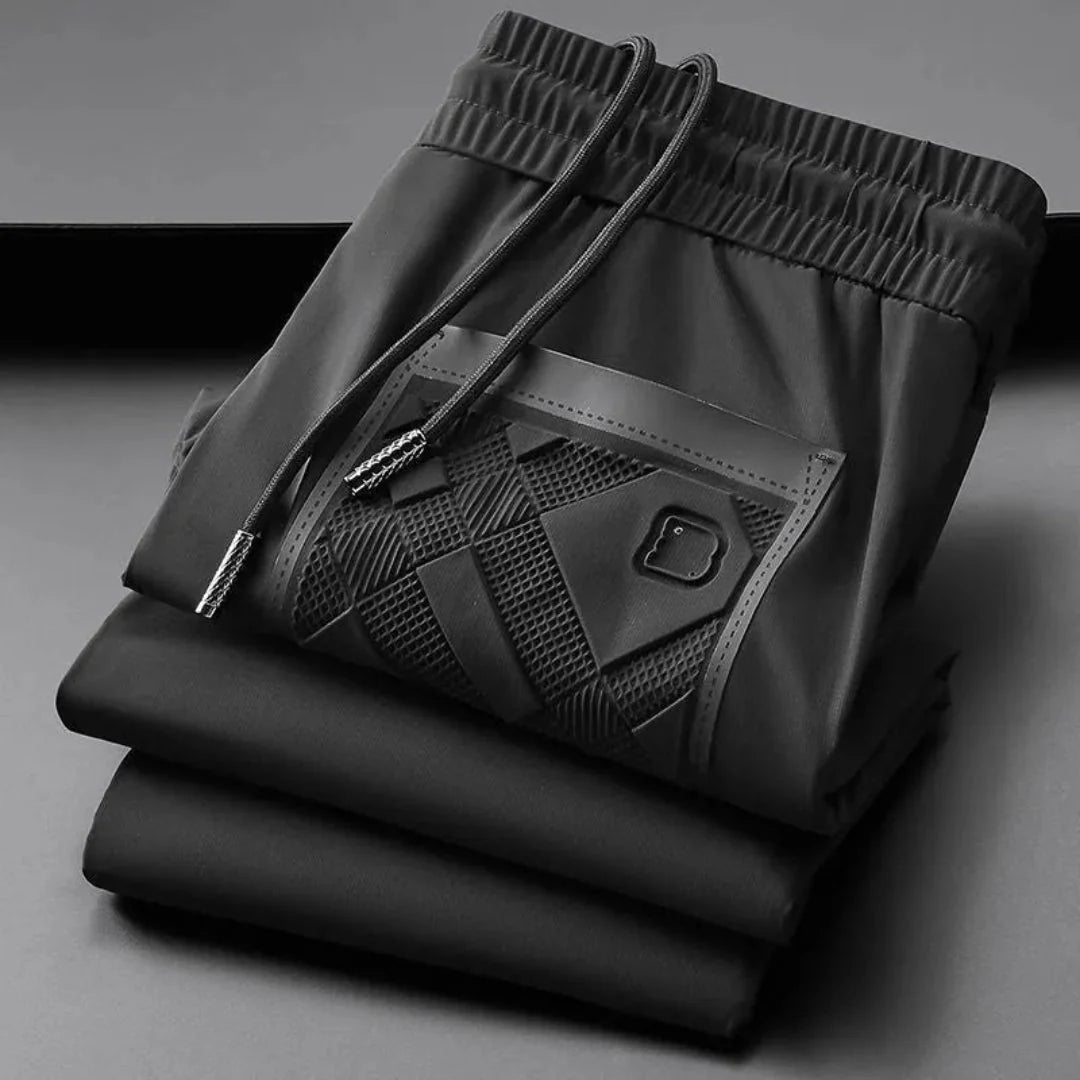 Men's slim-fit silk blend track pants with textured panels, sleek sheen, and streetwear-ready style