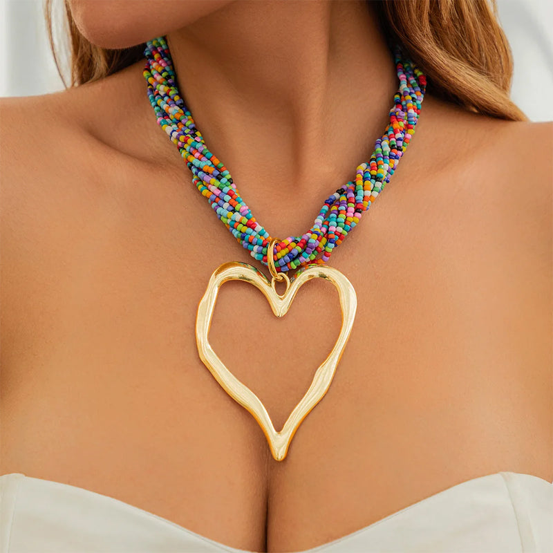 Oversized matte gold open heart pendant necklace with braided fabric strands, bold bohemian style