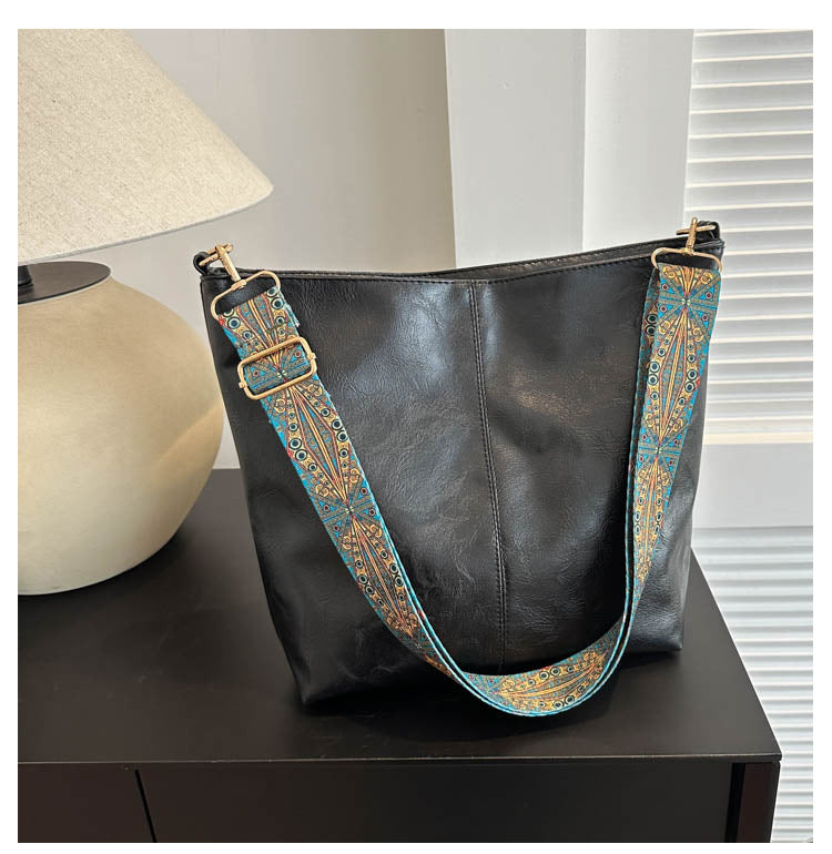 Tall vegan leather bucket bag with embroidered strap, structured silhouette, roomy interior, eco-chic everyday style