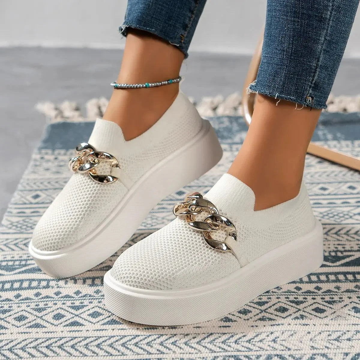 Women's white slip-on platform sneakers with breathable knit upper and chunky chain detail