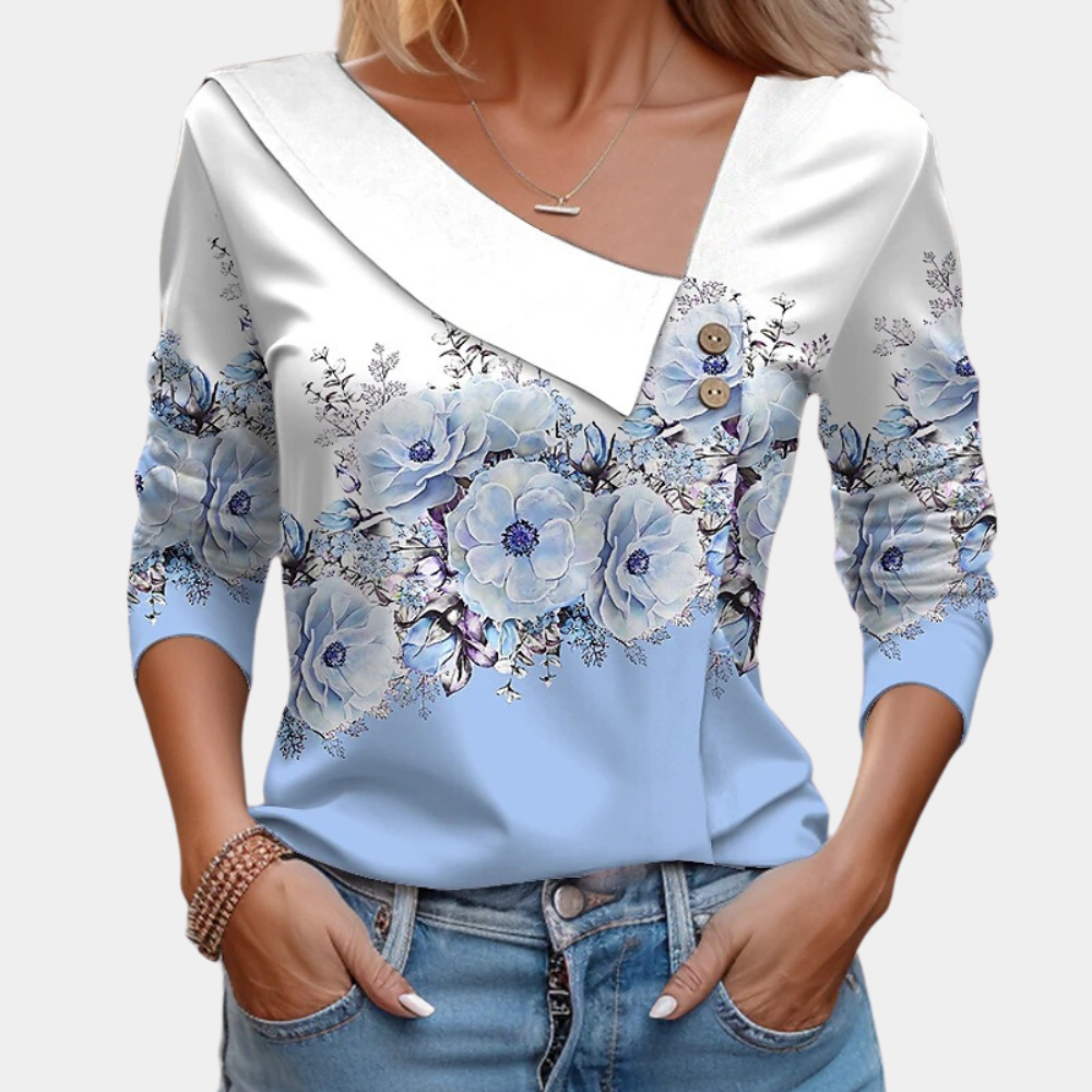 White polka dot loose-fit blouse with asymmetric neckline, long sleeves, and decorative buttons