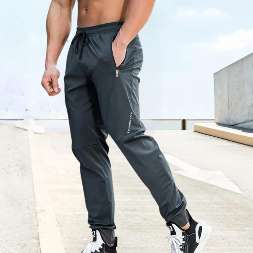 Men's slim fit gray jogging pants with elastic drawstring waist and secure zipper pockets
