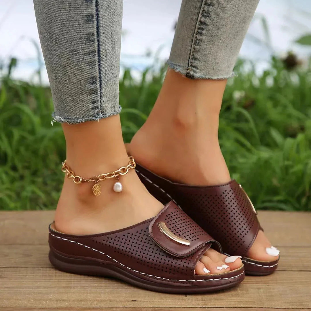Women's tan faux leather slip-on wedge sandals with perforated strap and cushioned sole