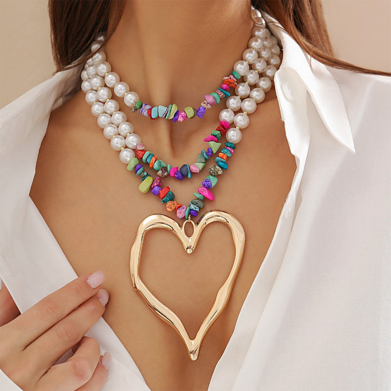 Multi-layer beaded statement necklace with faux pearls, colorful beads, and gold oversized heart pendant