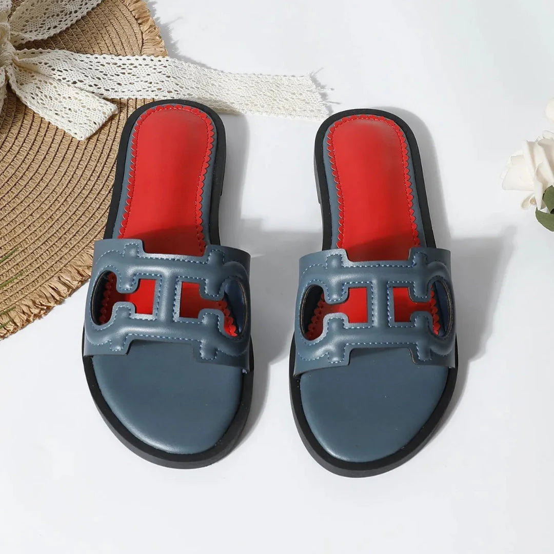 Celine black faux leather cutout slides with bold strap and vibrant red cushioned footbed