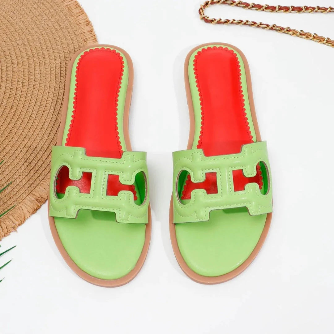 Celine black faux leather cutout slides with bold strap and vibrant red cushioned footbed
