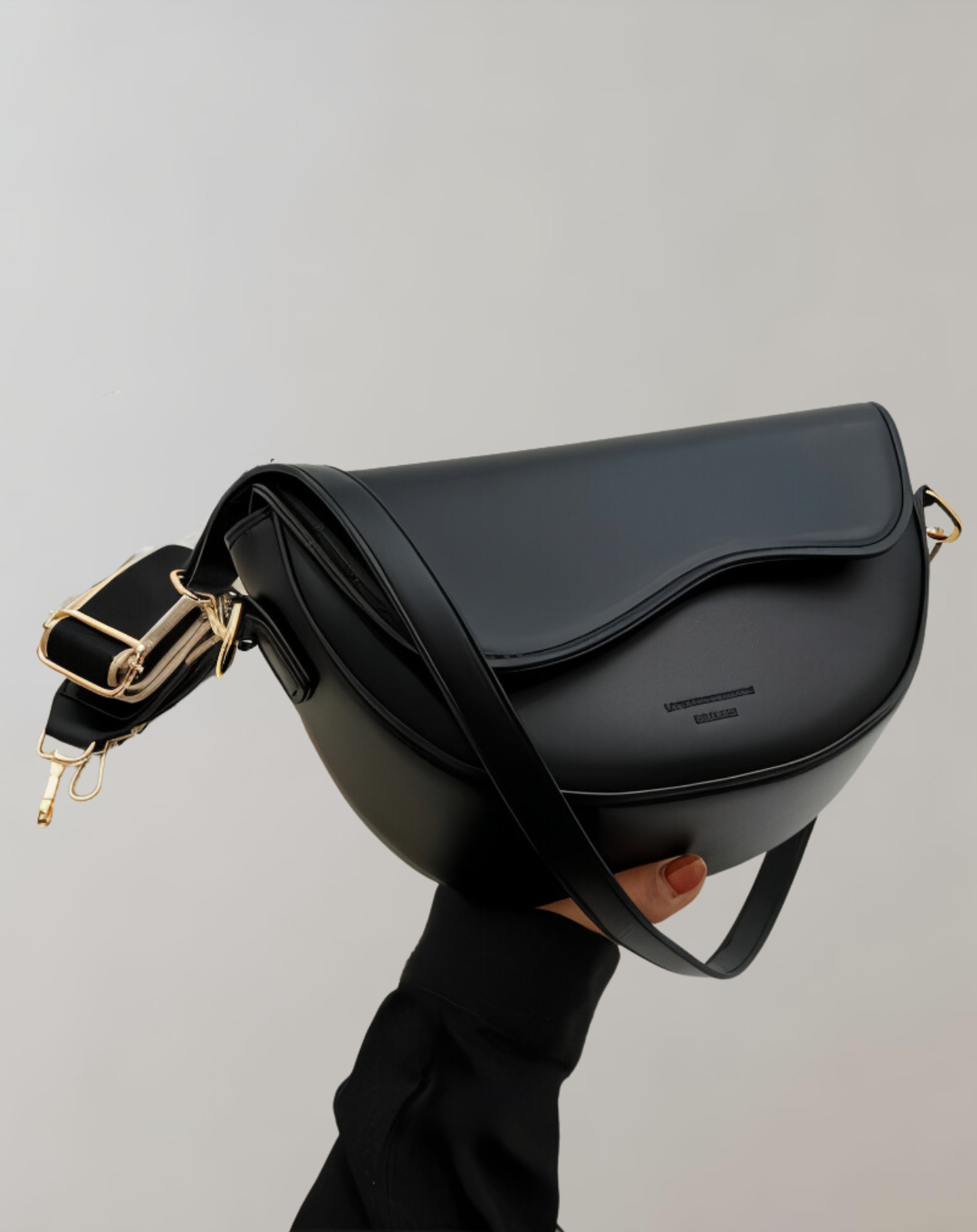 Women's vegan leather curved flap crossbody bag in sleek compact style with wide detachable strap