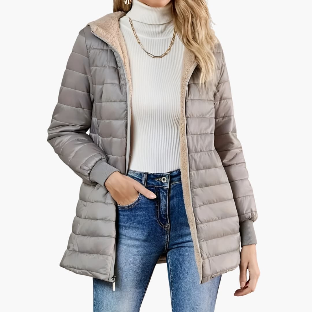 Women's longline quilted hooded coat with front zipper pockets and ribbed cuffs streamlined silhouette
