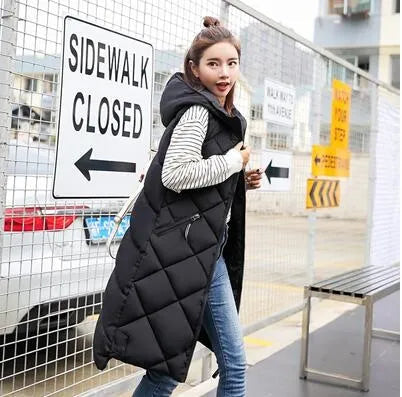 Women's long quilted hooded vest in neutral tones, sleeveless winter layering piece with textured stitching