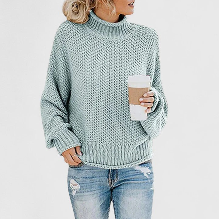 Women's chunky knit sweater in neutral tone, relaxed fit high neck cozy layering essential