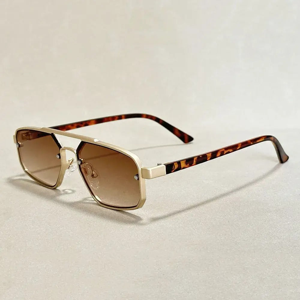 Geometric gold-tone gradient sunglasses with dark UV-protective lenses and sharp angular minimalist frame