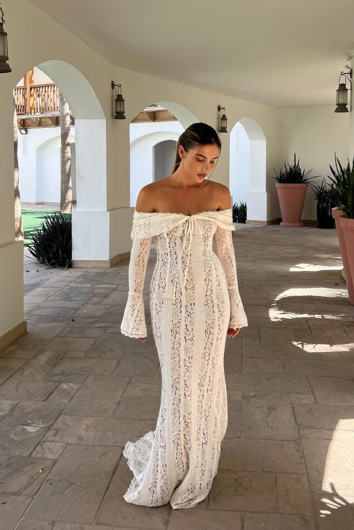 Ivory off-shoulder lace maxi dress with flared sleeves, fitted bodice, and floor-sweeping hem