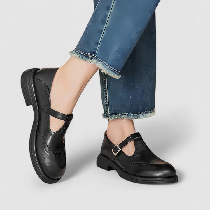 Women's brown leather T-strap brogue shoes with adjustable buckle closure and elegant perforated detailing