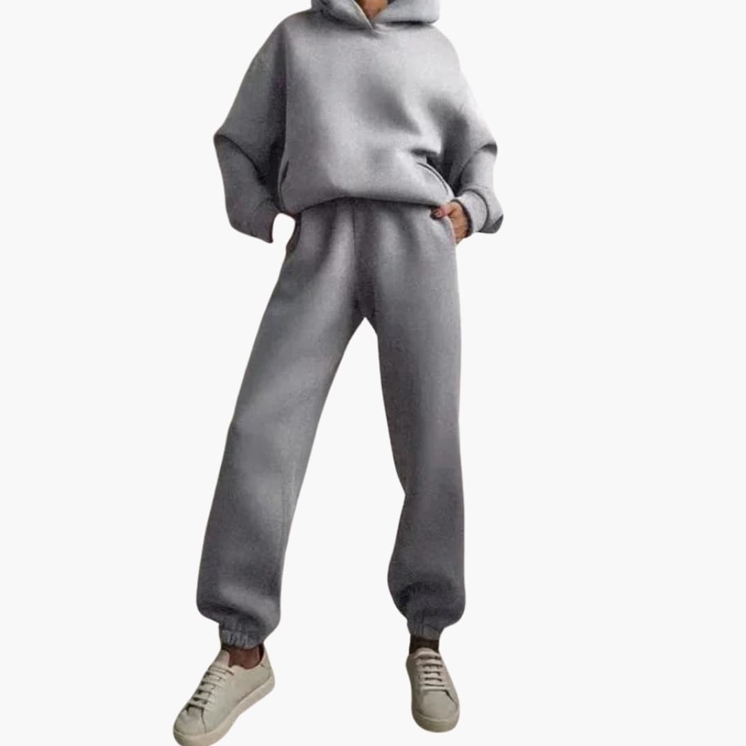 Women's gray hoodie and jogger set with elastic waist, pockets, and fitted hooded silhouette