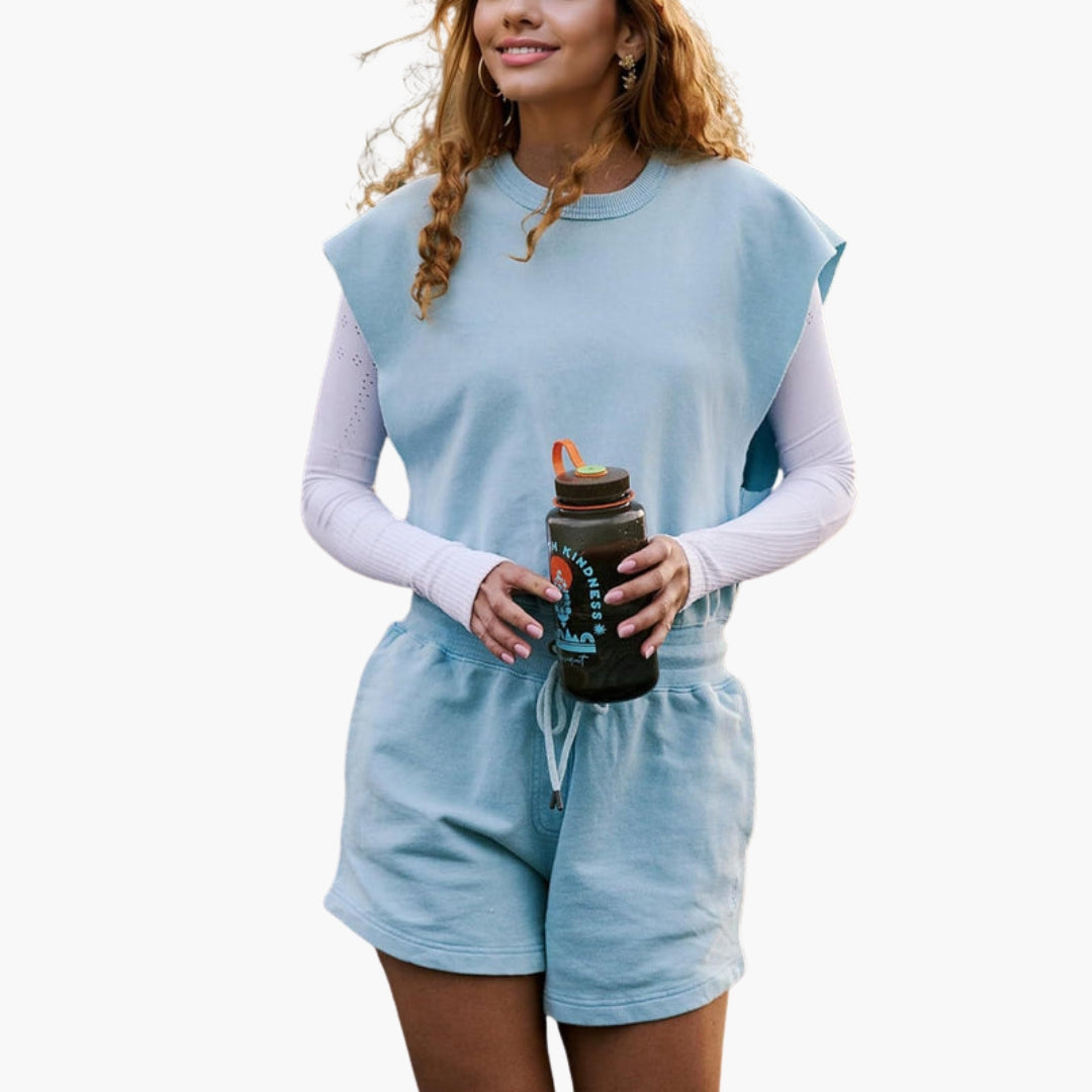 Women's gray two-piece activewear set with drawstring shorts, relaxed short-sleeve top, and elastic waist