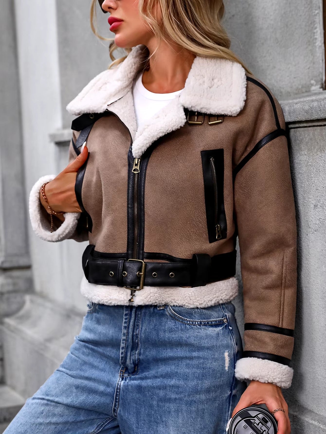 Women's cropped sherpa coat with plush lining, cozy vintage style, and leather strap accents