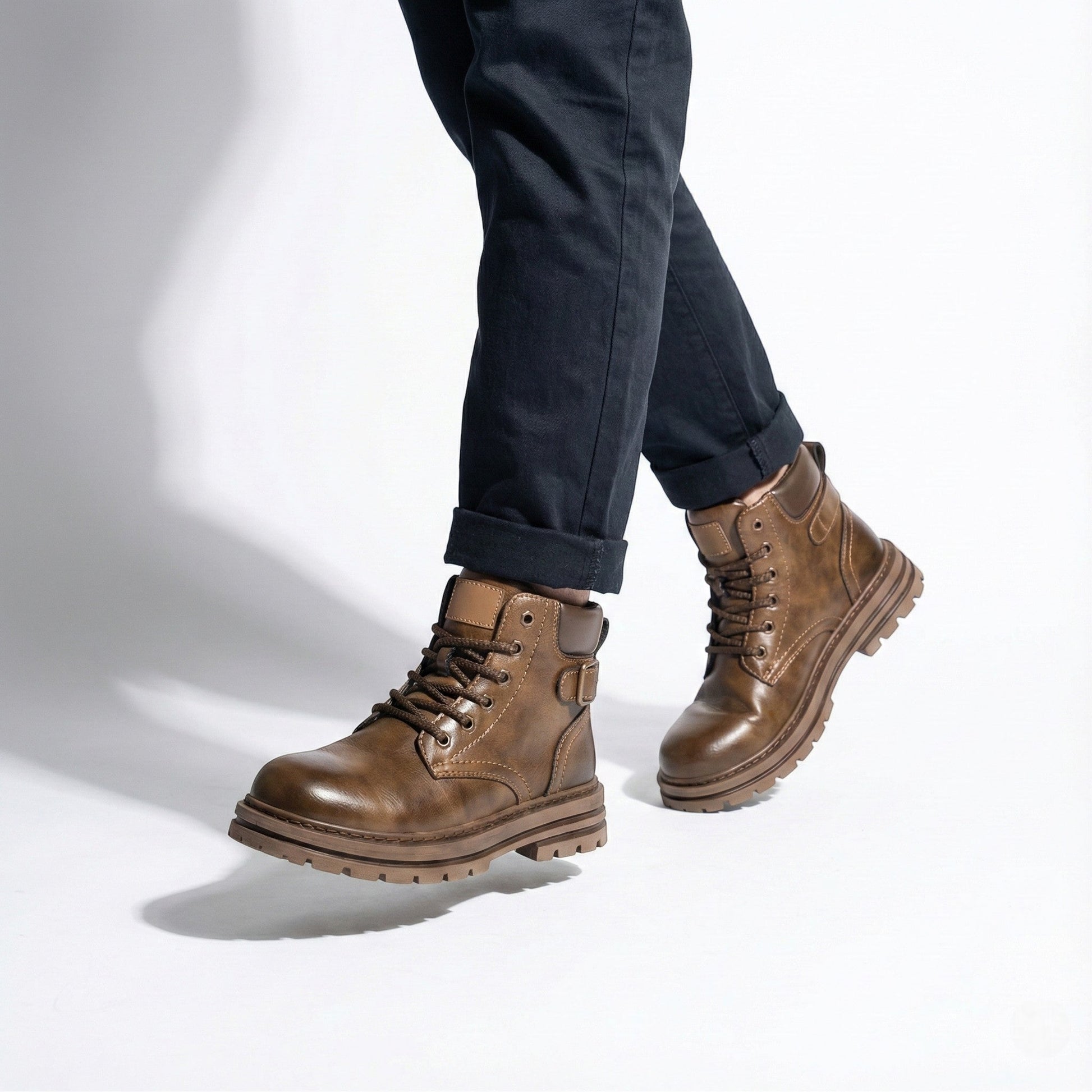 Men's black leather combat boots with chunky lug sole, ankle buckle, and non-slip rubber outsole