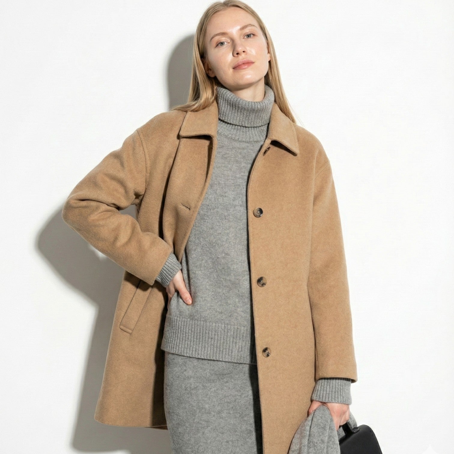 Women's loose wool blend coat in neutral tone with button closure and elegant draped silhouette