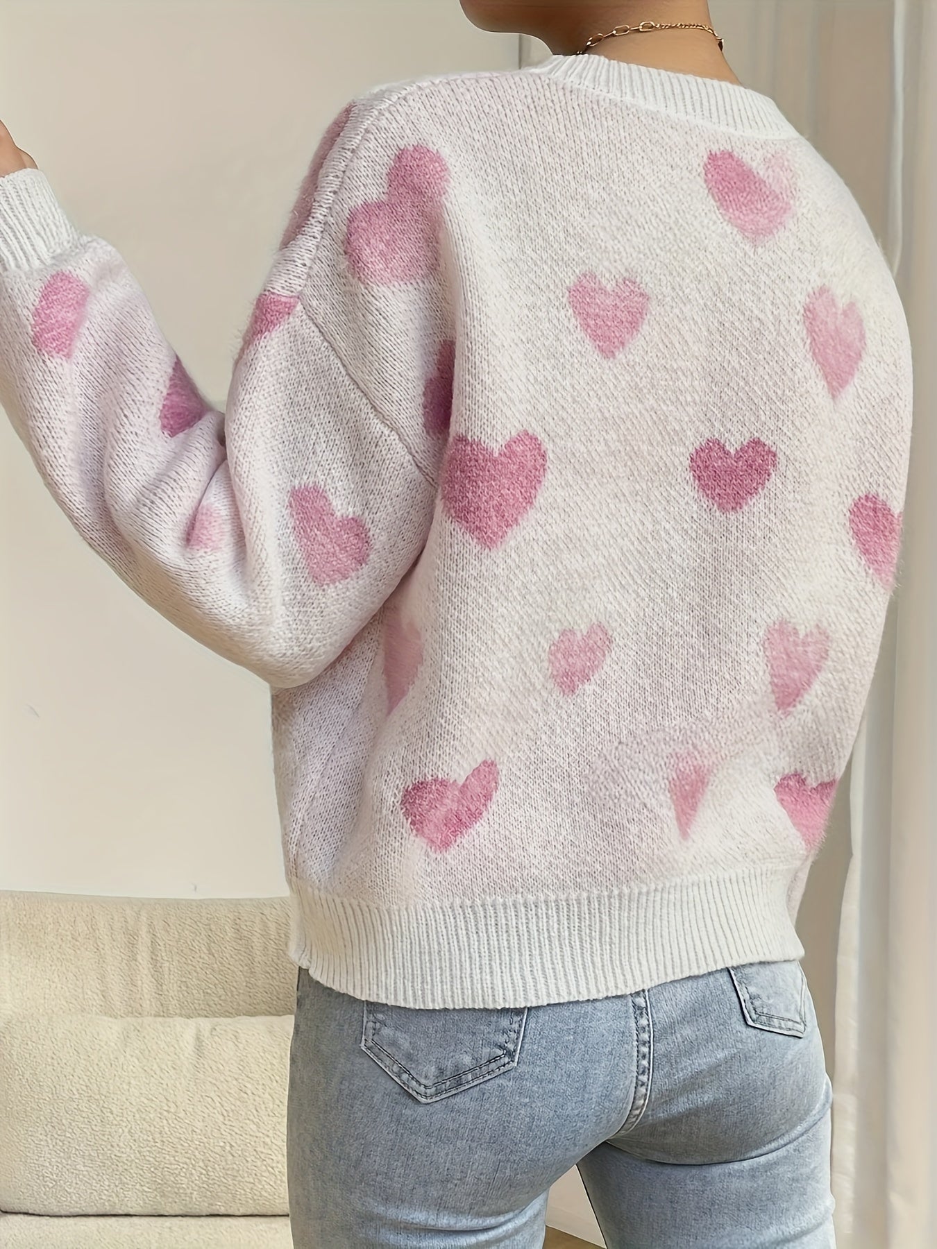 Women's cozy knit sweater in warm tones with playful heart design, perfect for autumn winter