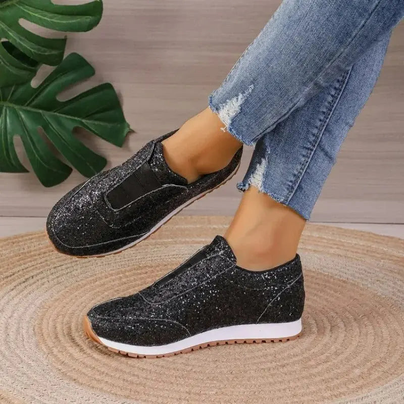 Women's glitter slip-on sneakers with elastic fit, cushioned sole, and sparkle finish for all-day comfort