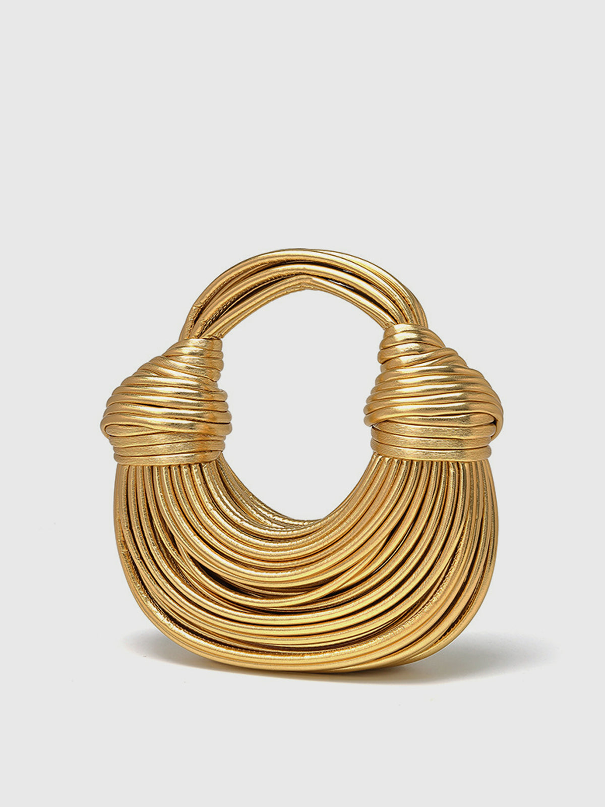 Golden twisted hoop bag sculptural wearable art metallic sheen multi-layered architectural silhouette