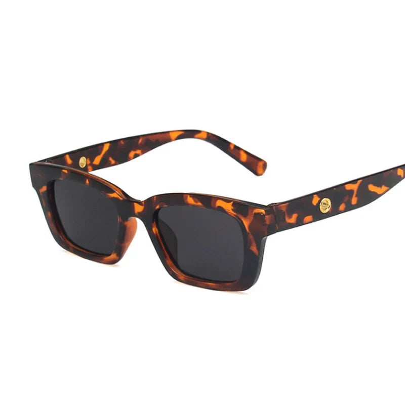 Bold black rectangular wayfarer sunglasses with dark lenses and gold-tone temple accents