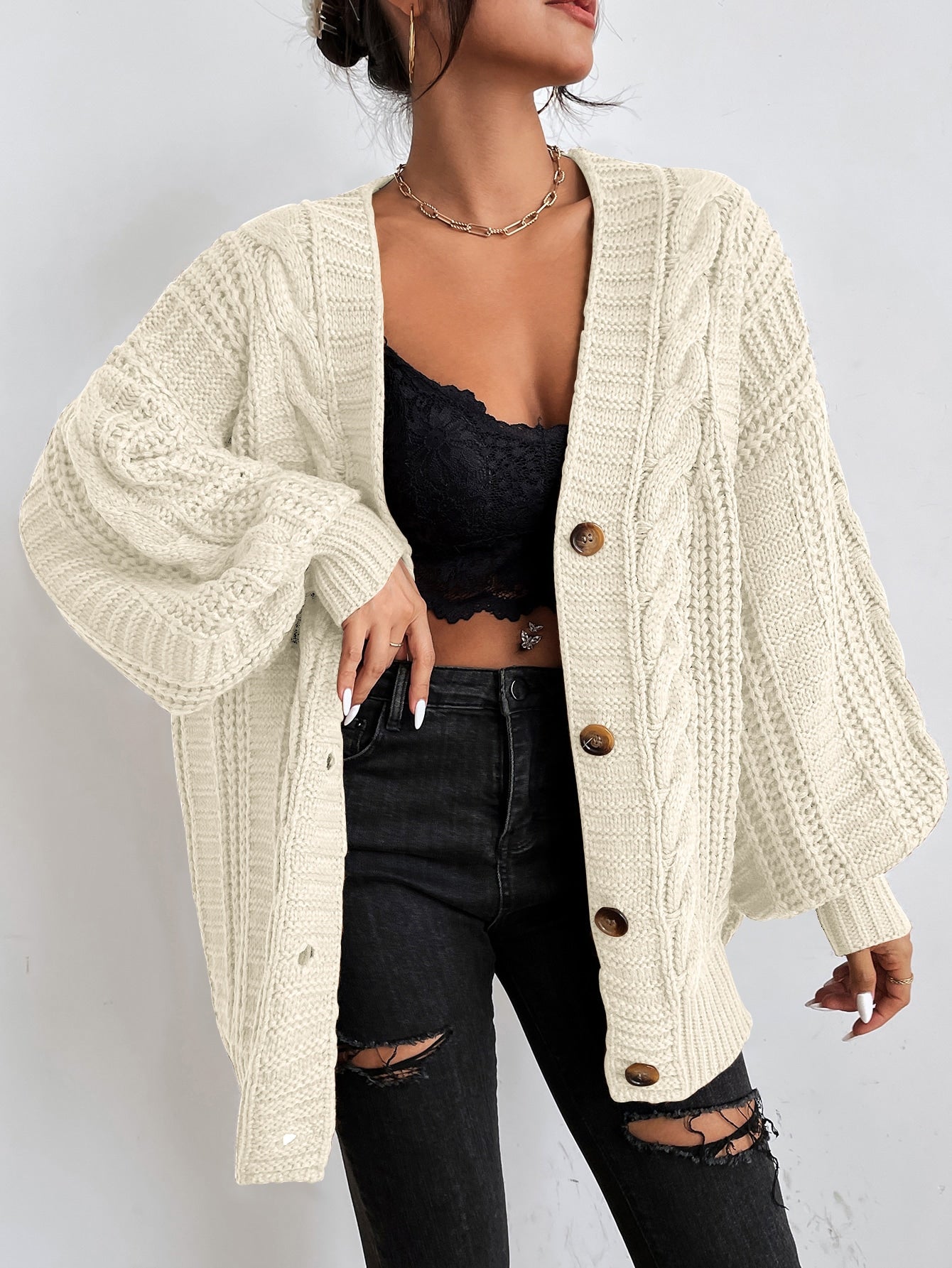 Women's oversized cream cable knit cardigan with dropped shoulders, chunky texture, and relaxed fit