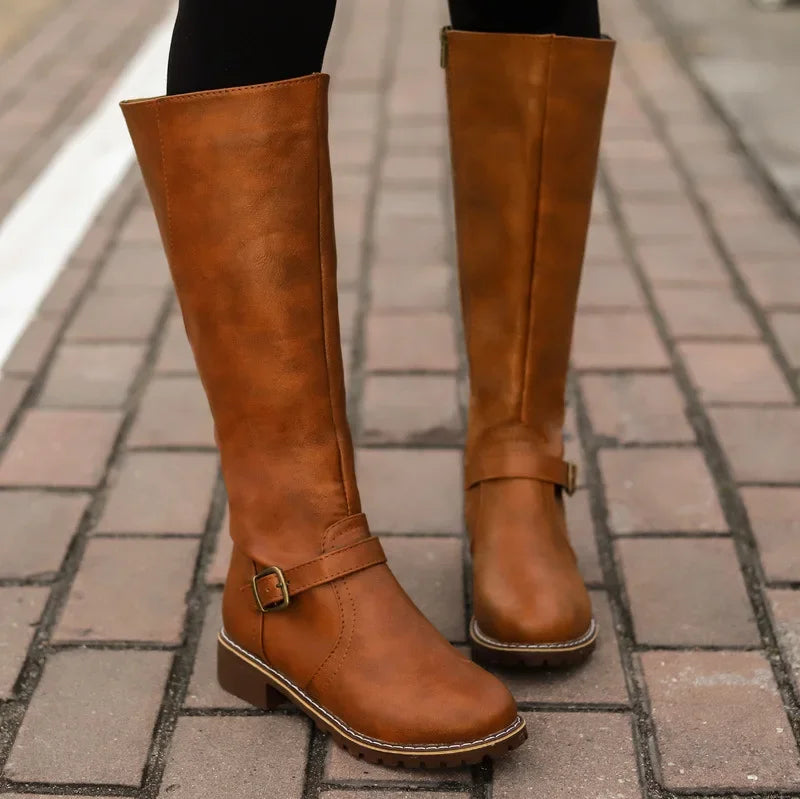 Women's black high-top biker boots with bold chunky heel and silver belt buckle detail